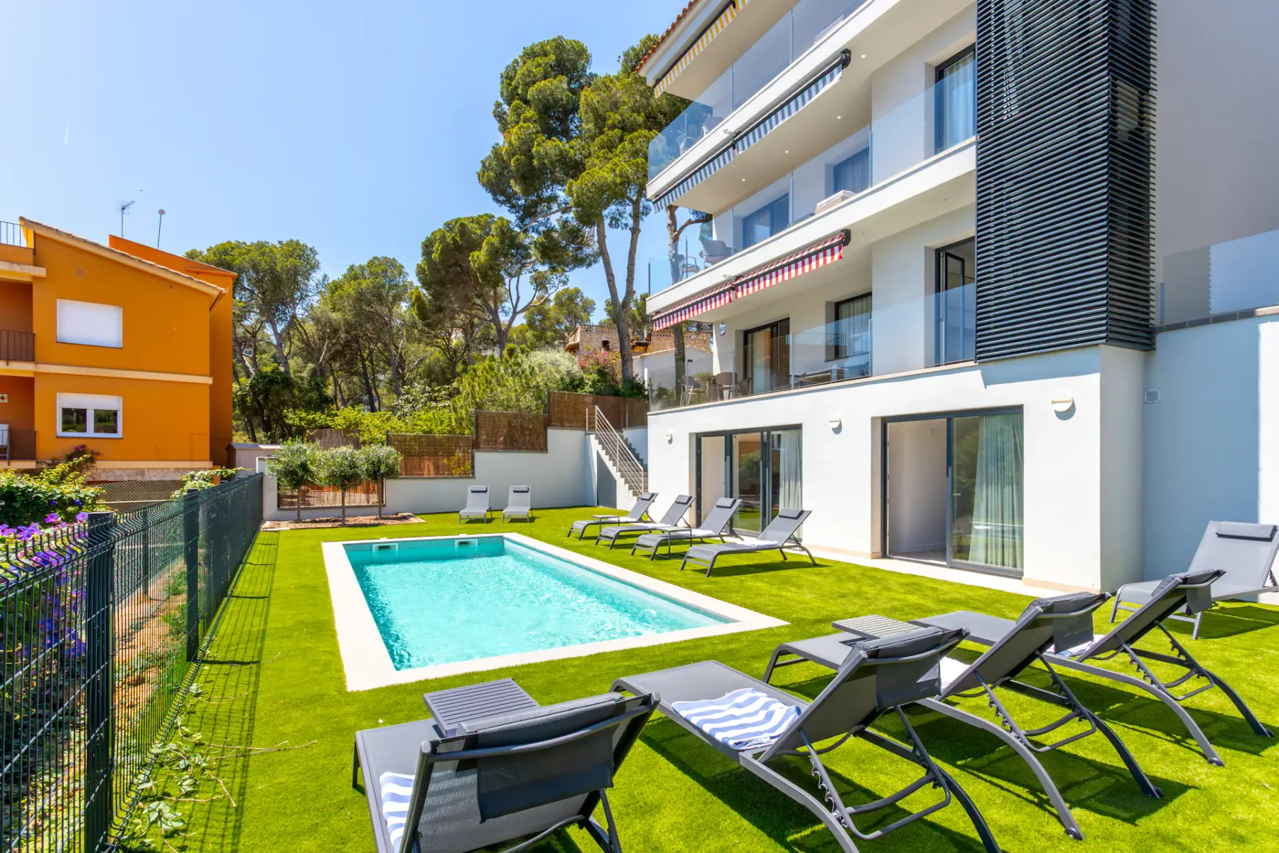 Shared amenity: A shared outdoor pool area has lounge seating beside a modern building.