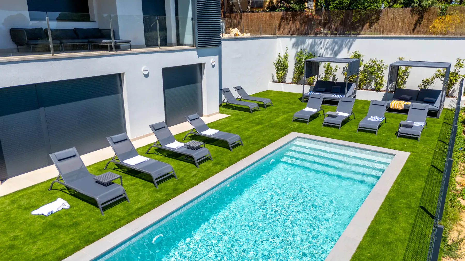 Shared amenity: A rectangular pool is surrounded by lounge seating on a grassy patio.