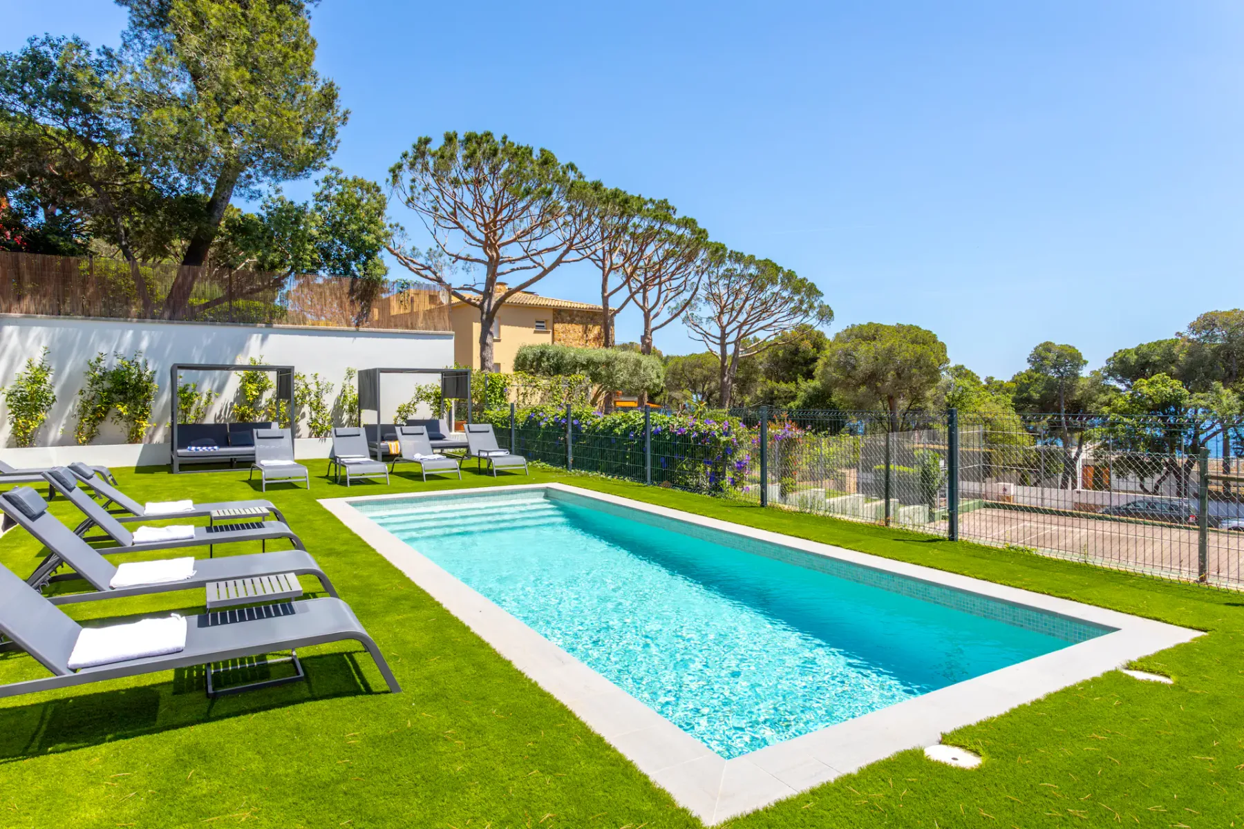 Shared amenity: An outdoor swimming pool is surrounded by lounge seating and green lawn.