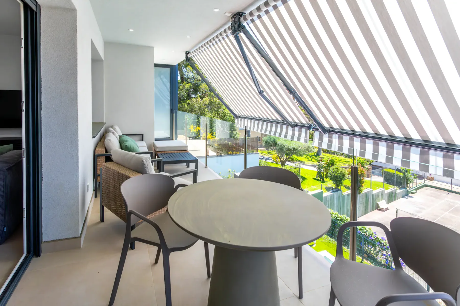 A covered terrace dining area overlooks a landscaped courtyard with a swimming pool.