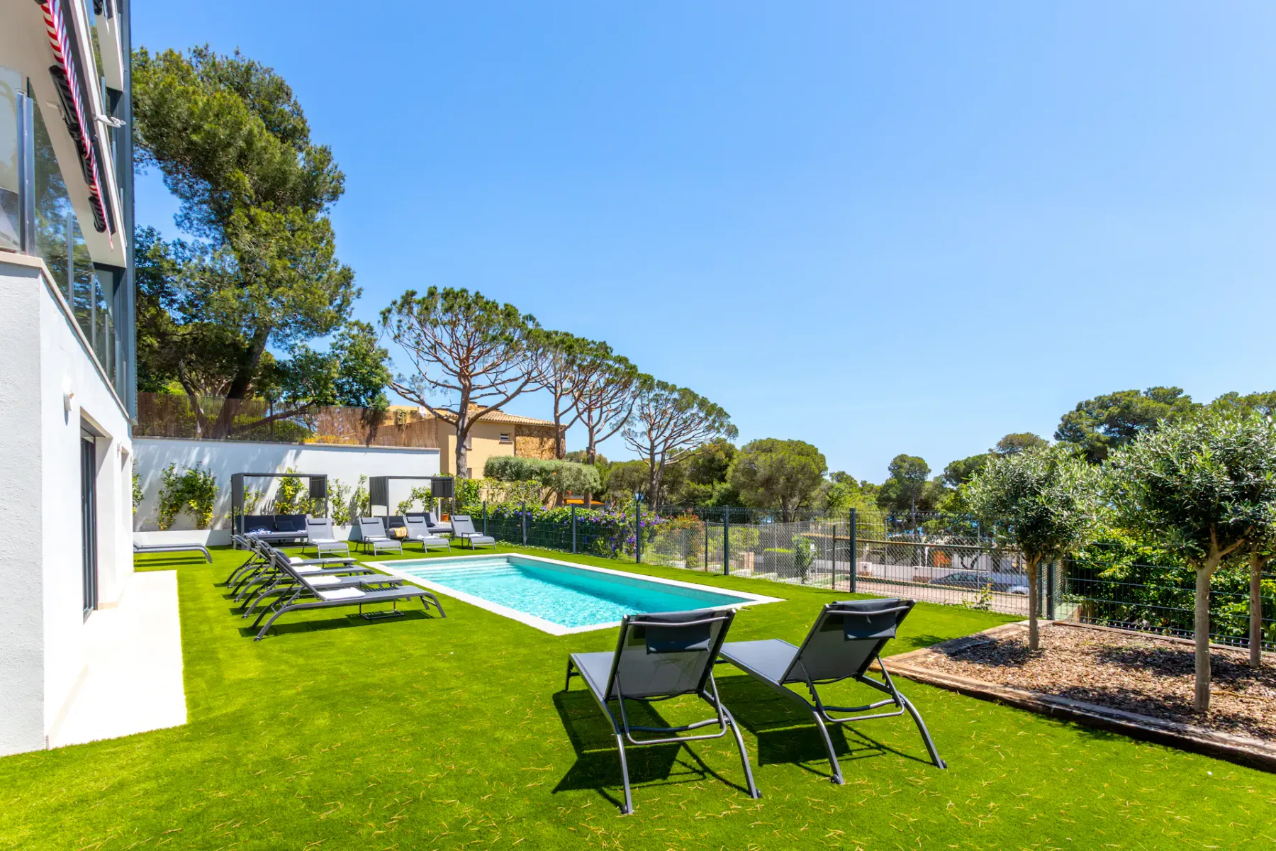 Shared amenity: Outdoor pool area with lounge chairs on a lawn.