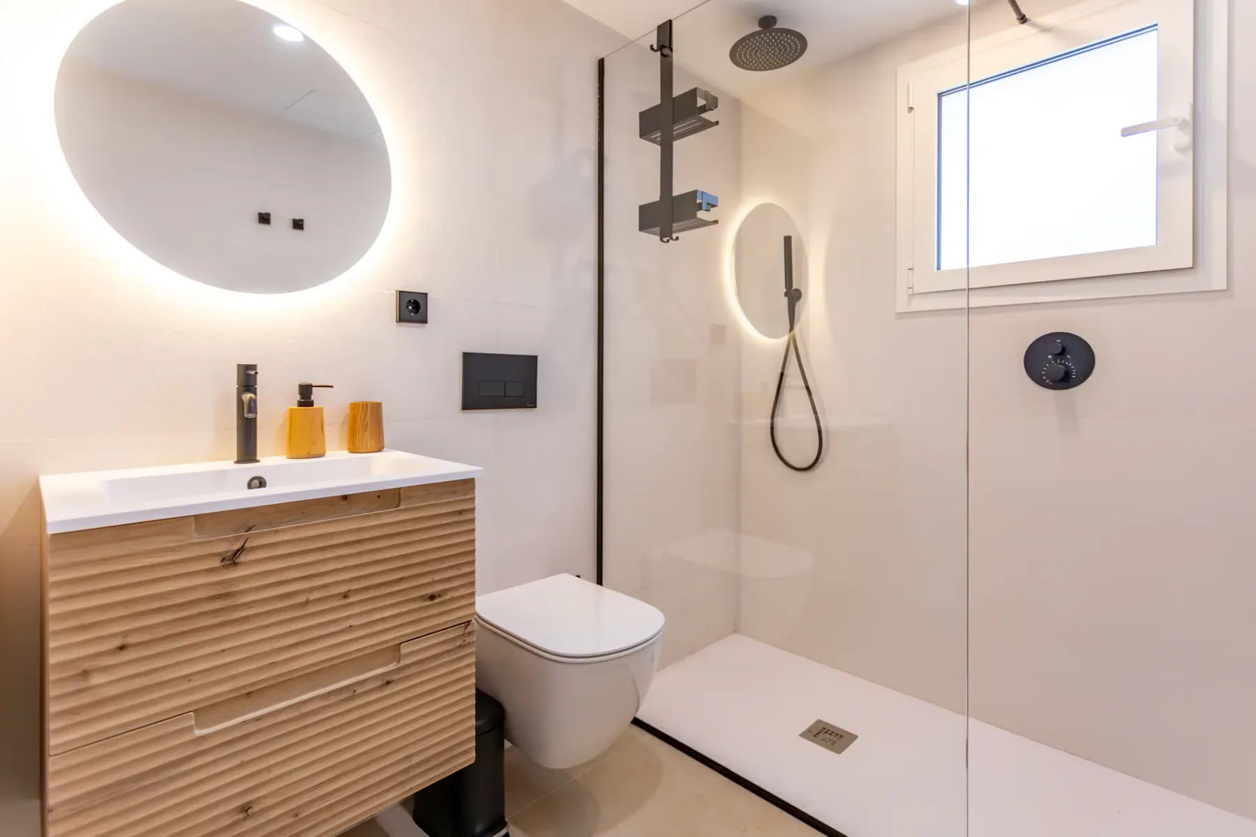 A modern bathroom with a vanity, toilet, and walk-in shower.