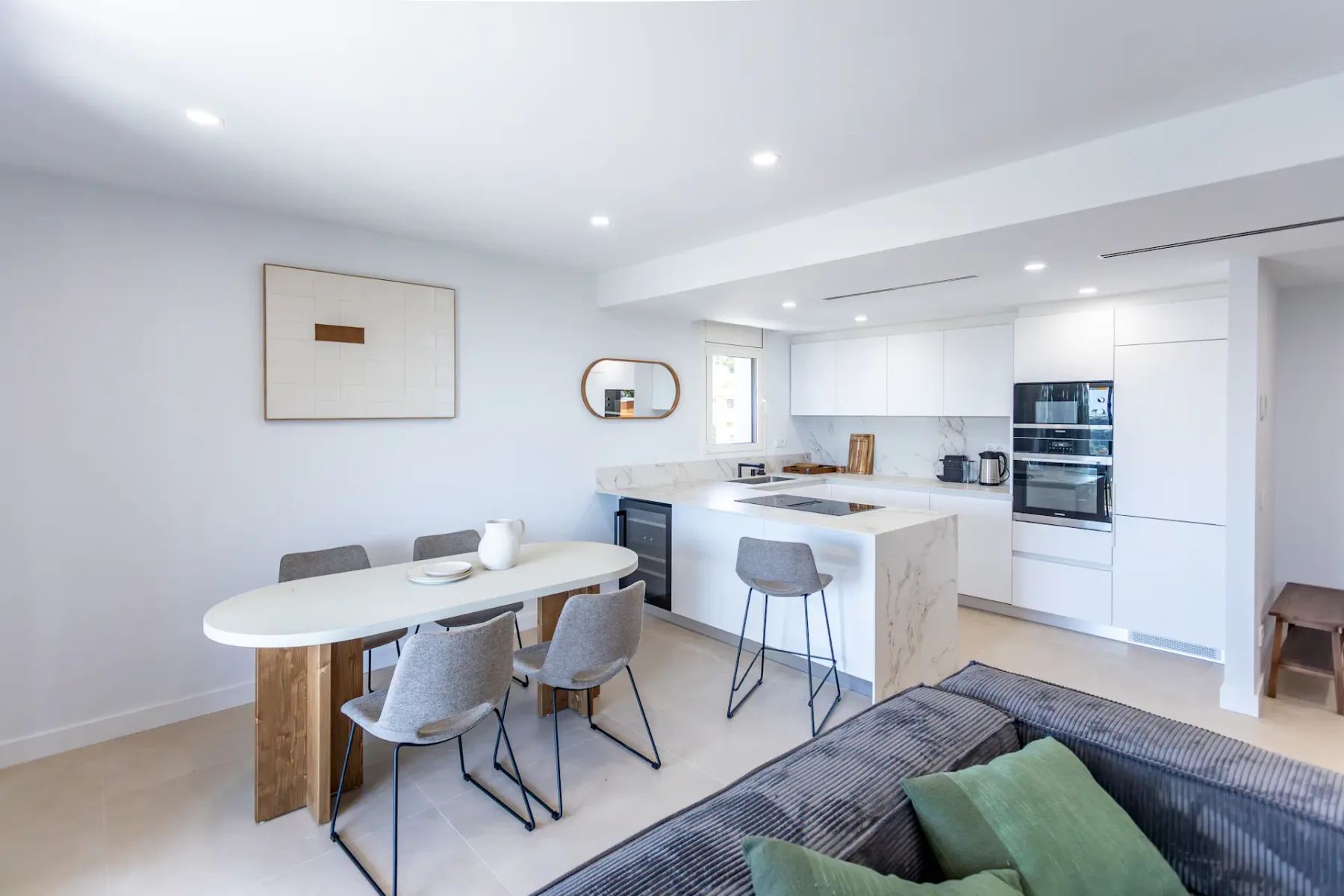 A bright open-plan kitchen and dining area with a table and central island.