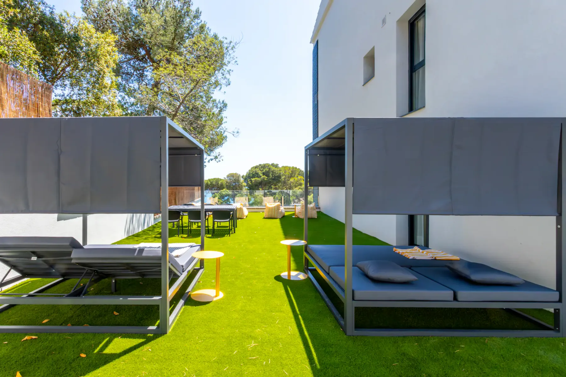 Shared amenity: Outdoor seating area with shaded lounge beds arranged along a green lawn.
