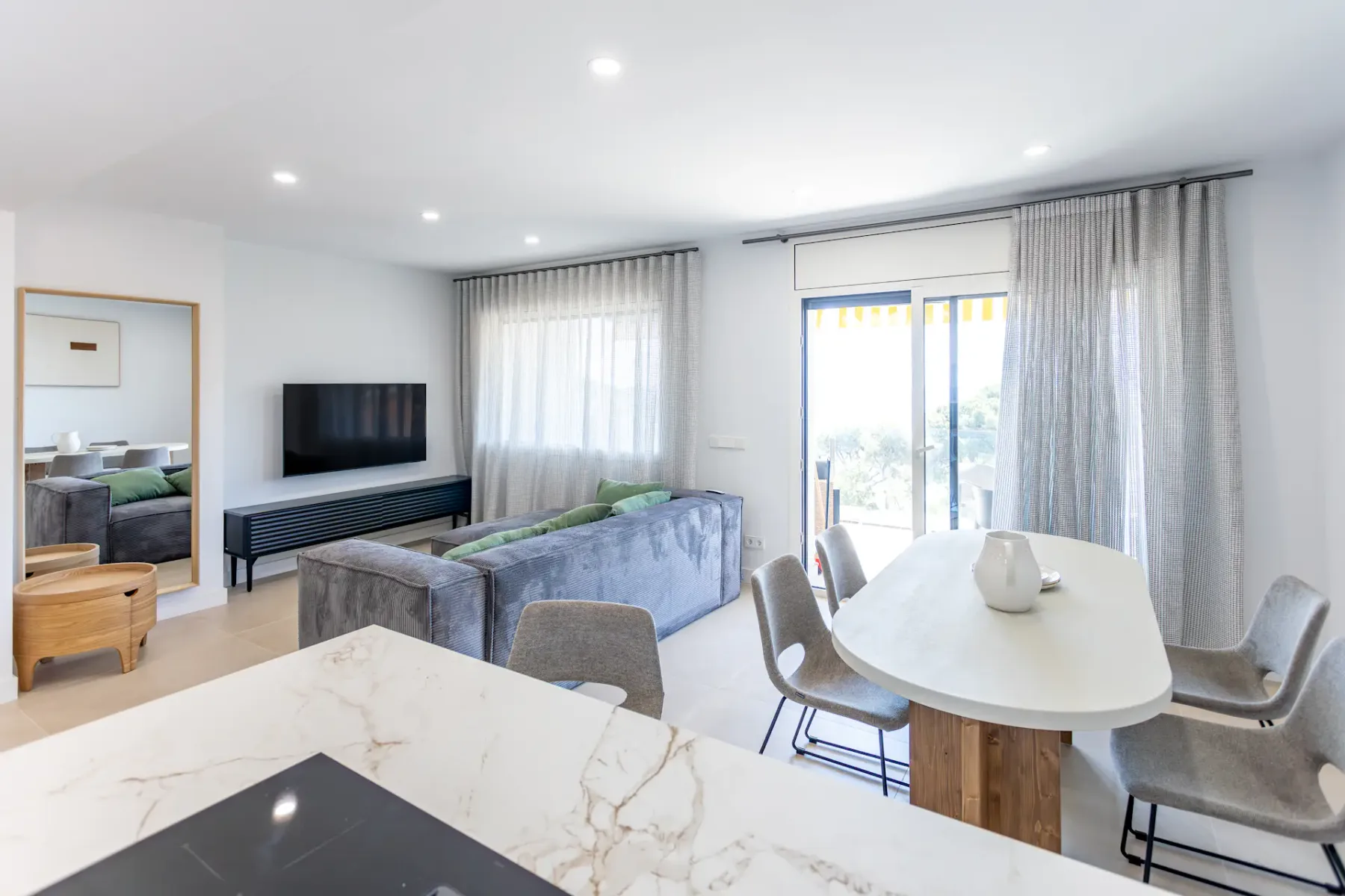 A bright open-plan living and dining room with a sofa and dining table.
