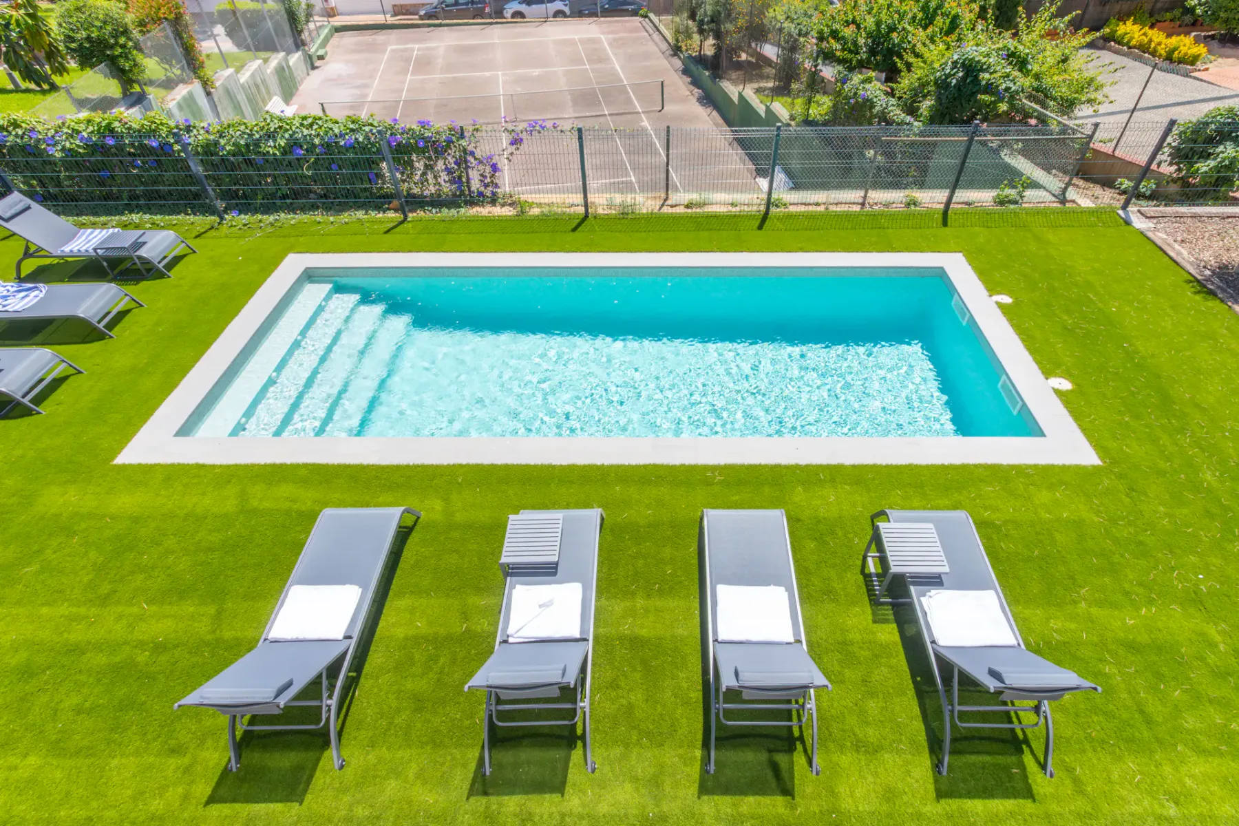 Shared amenity: Outdoor swimming pool set in a lawn, with lounge chairs nearby.