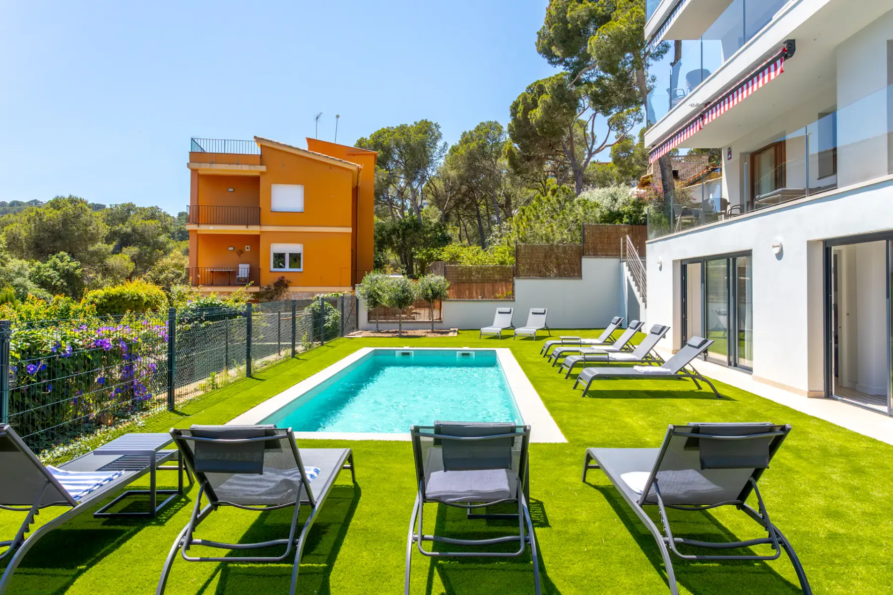Shared amenity: An outdoor swimming pool is surrounded by lounge seating and green lawn.