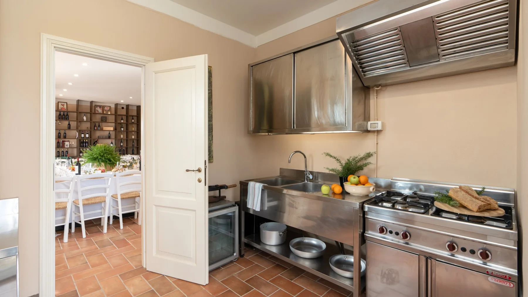 Una cocina con encimeras de acero inoxidable, un fregadero y equipo de cocina.