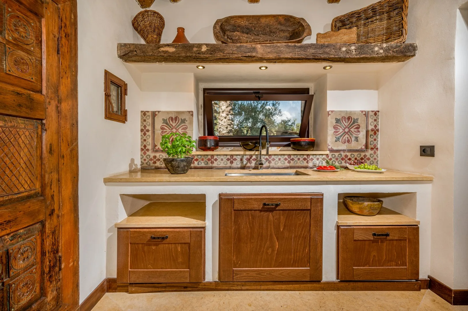 Una cocina rústica con gabinetes de madera, una encimera y una ventana sobre el fregadero.