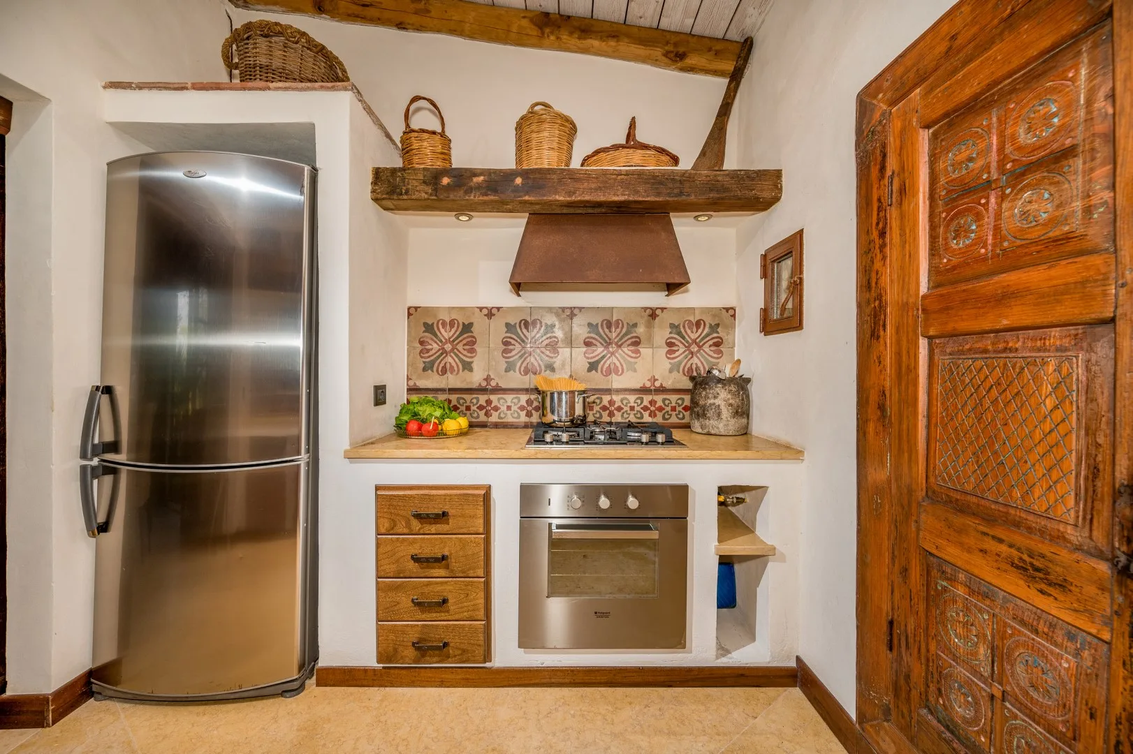 Una cocina rústica con refrigerador de acero inoxidable y salpicadero estampado.