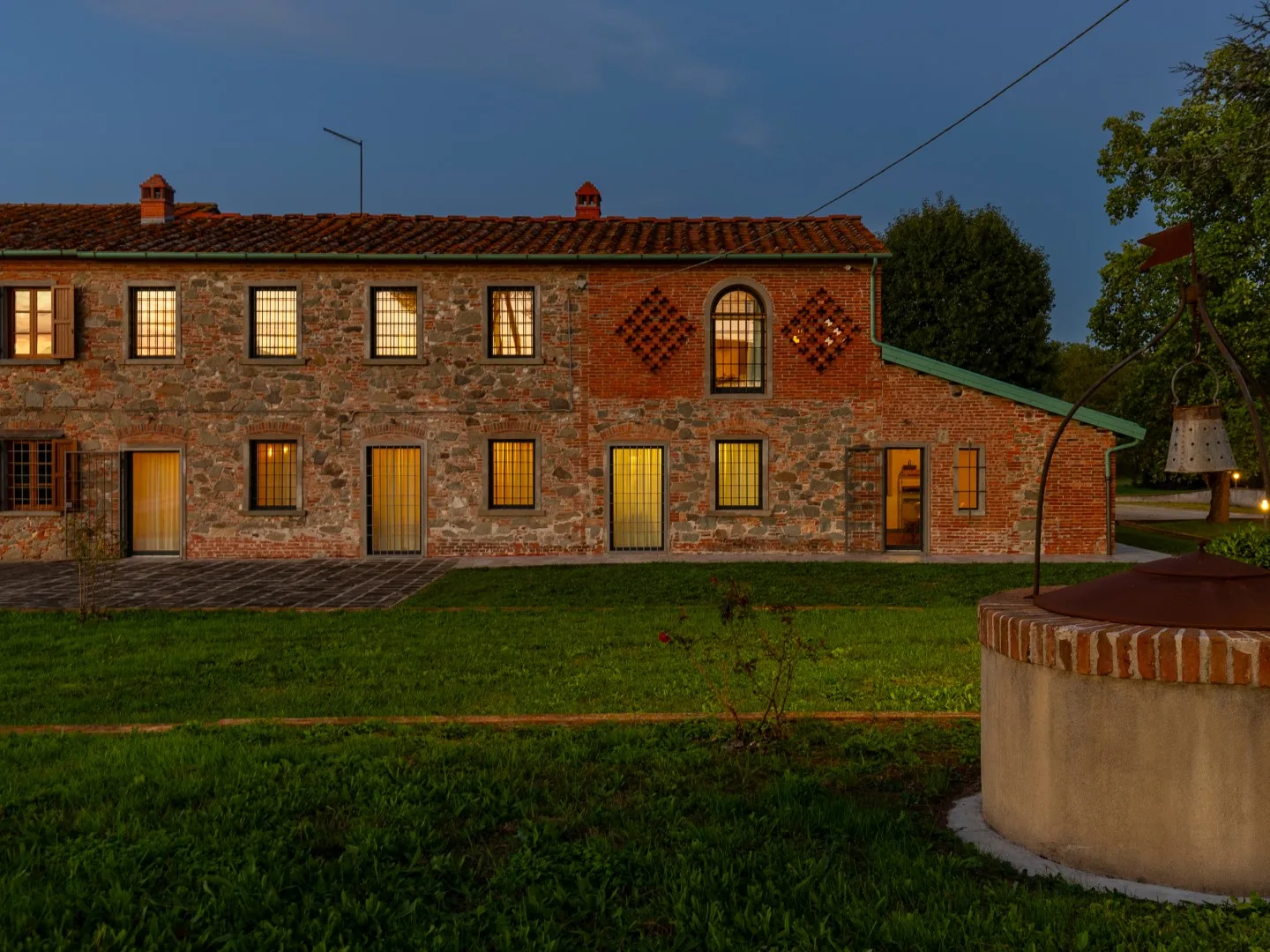 Una casa de ladrillo con techo de tejas se alza junto a un césped.