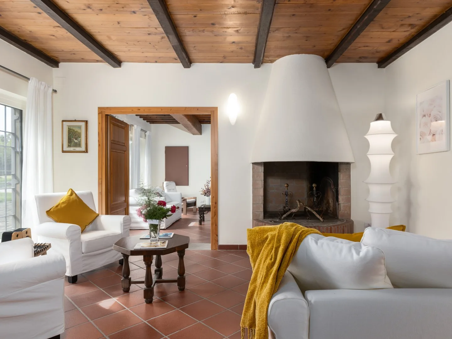 Una sala de estar con asientos alrededor de una mesa de centro y una gran chimenea.