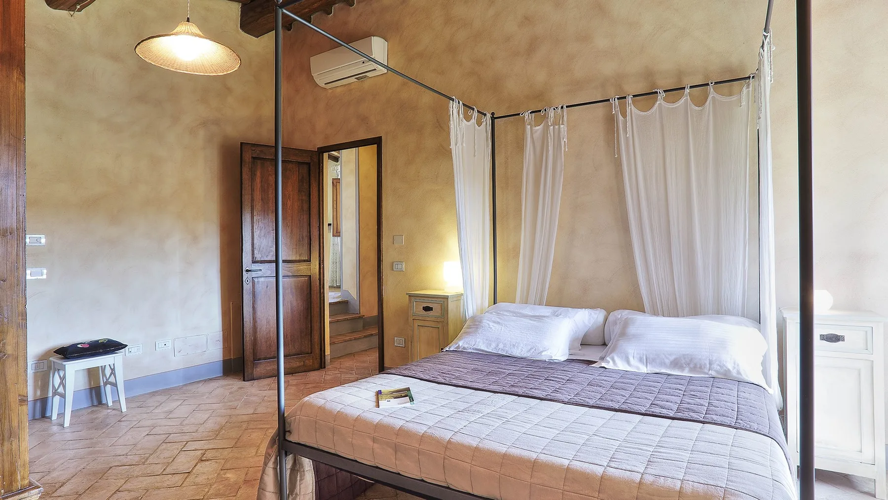 A bedroom with a large bed, bedside tables, and curtains.