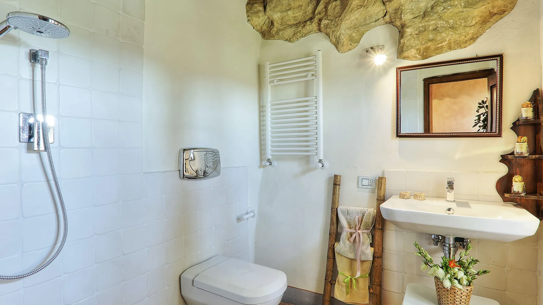 A tiled bathroom with a shower, sink, and wall mirror.