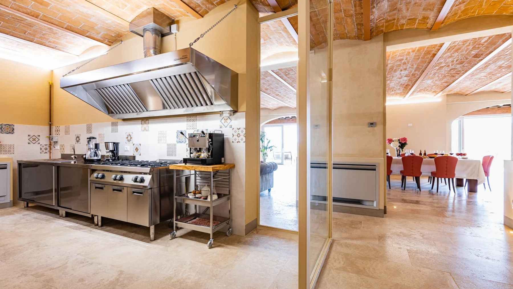 A spacious kitchen with stainless steel appliances opens onto a dining area.
