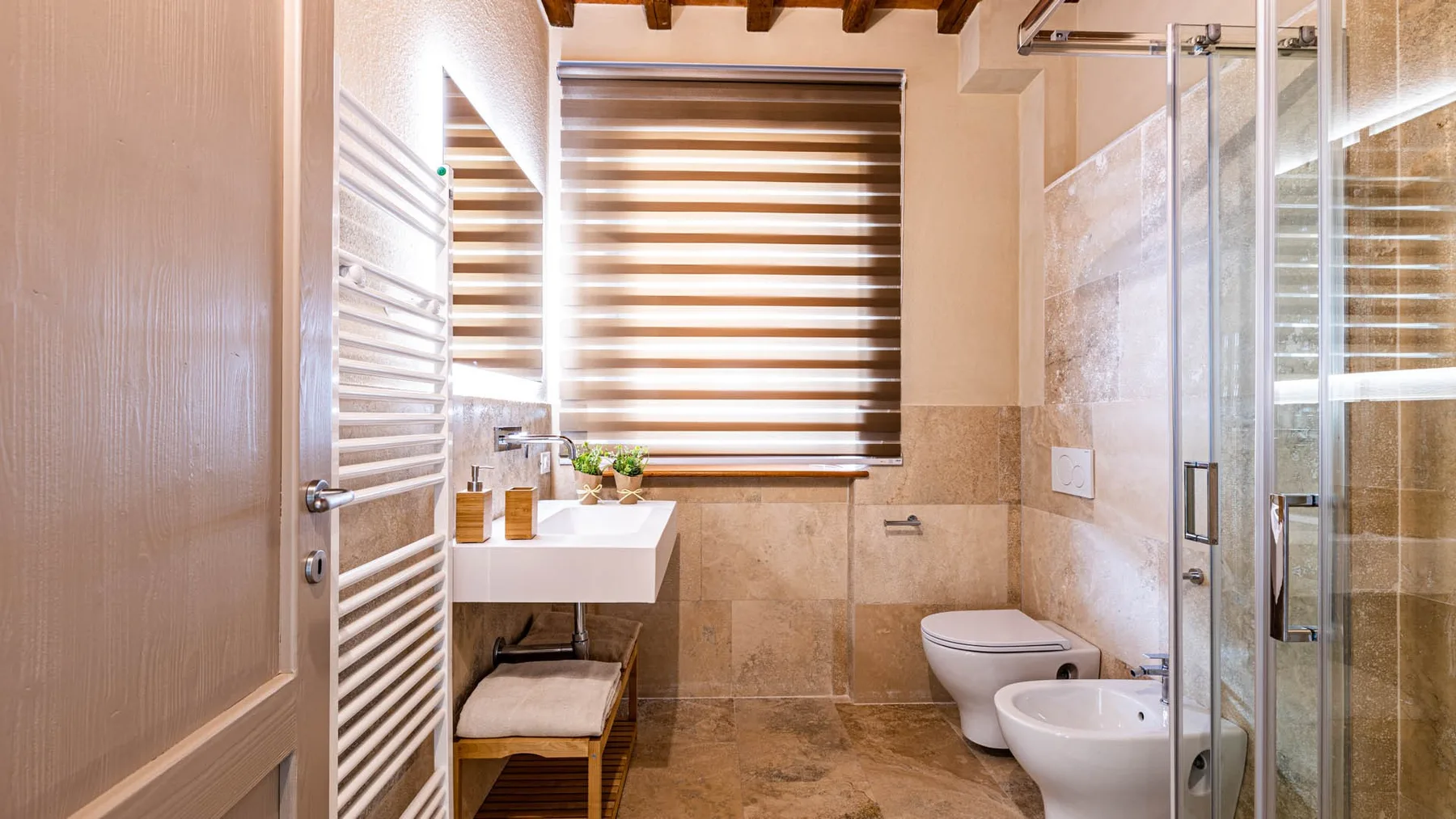 A bathroom with a sink, toilet, and glass shower.