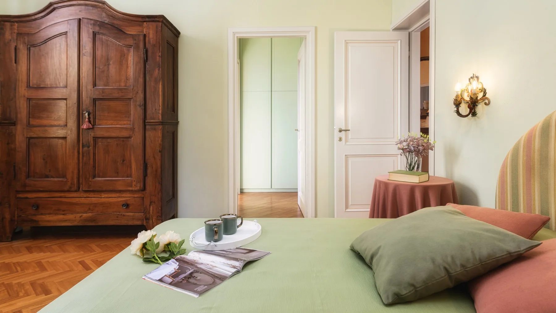 Un dormitorio con una cama, un armario de madera y una puerta abierta.