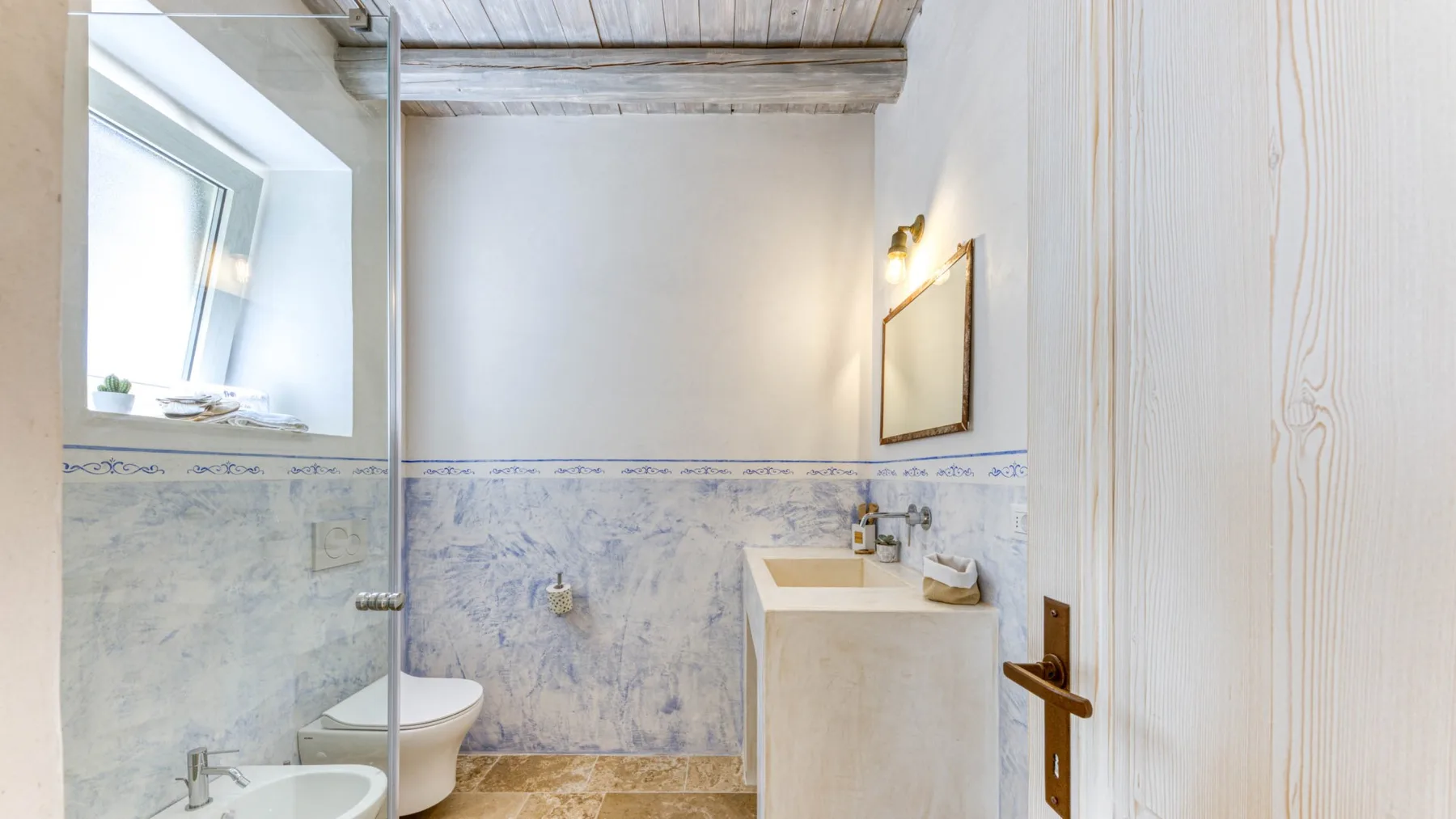 Un baño con bañera, lavabo y ventana.