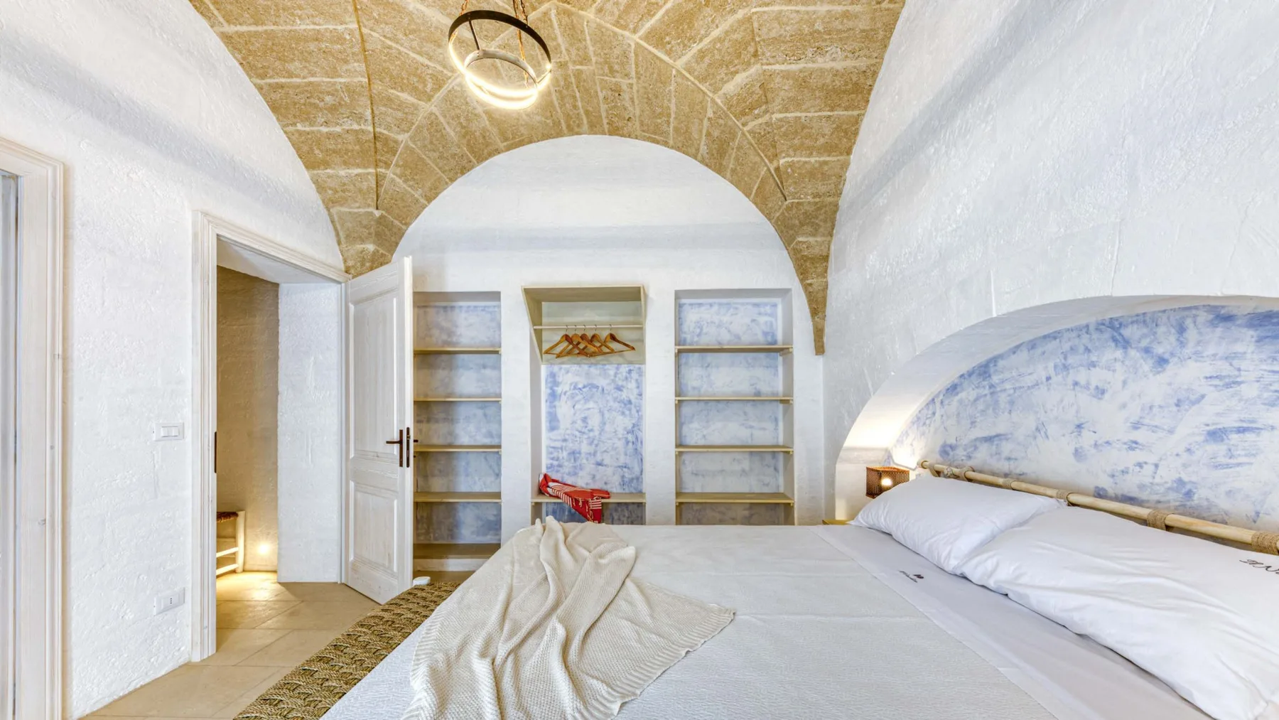 Un dormitorio con una cama bajo un techo curvo y texturizado.