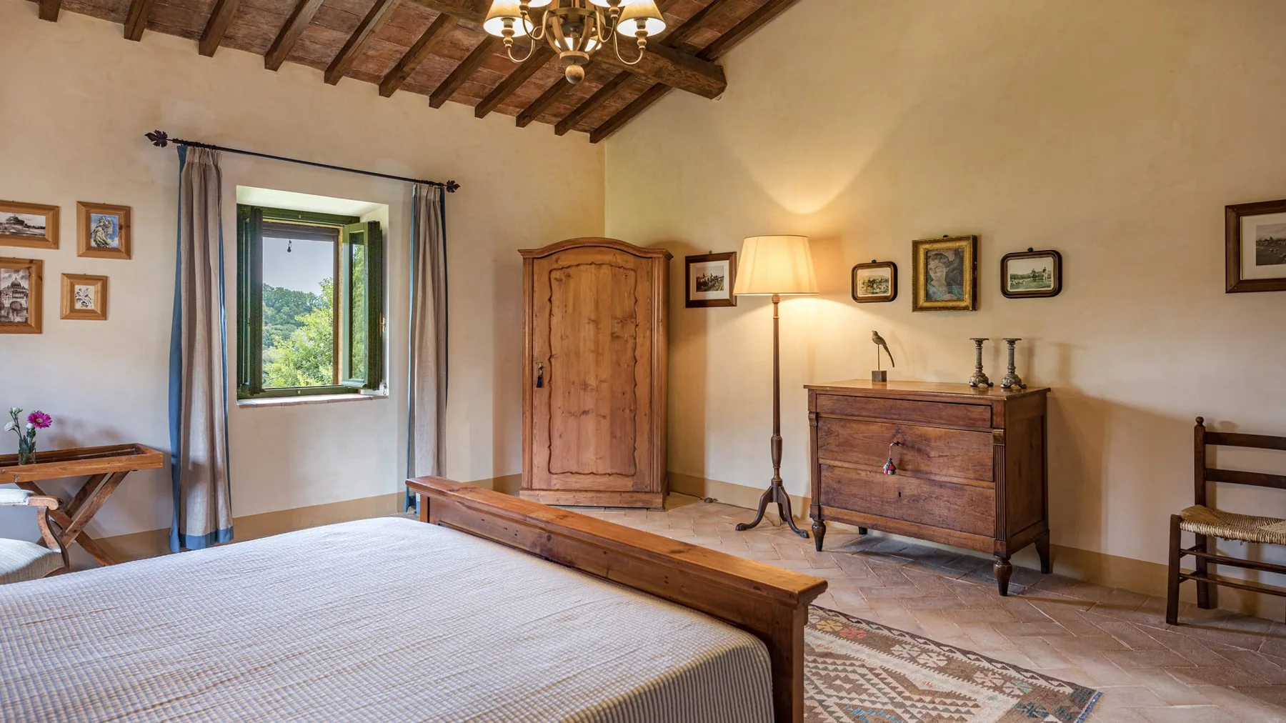 A bedroom with a wooden bed, a wardrobe, and a chest of drawers.