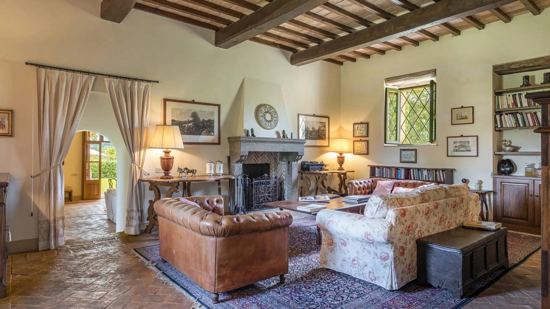 A rustic living room with seating arranged around a fireplace and patterned rug.