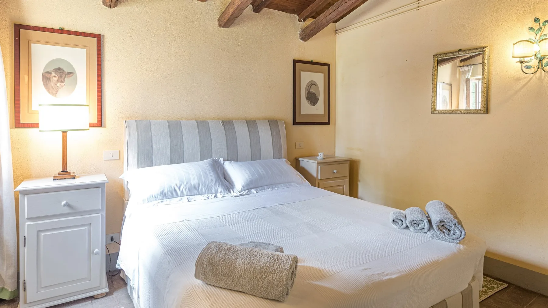 A bedroom with a neatly made bed and bedside tables.