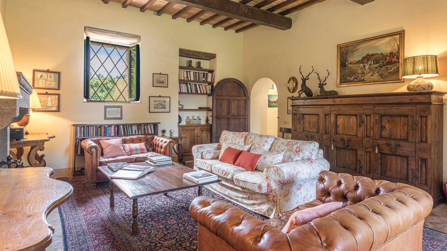 A traditional living room with patterned seating, a wooden coffee table, and a large wooden cabinet.