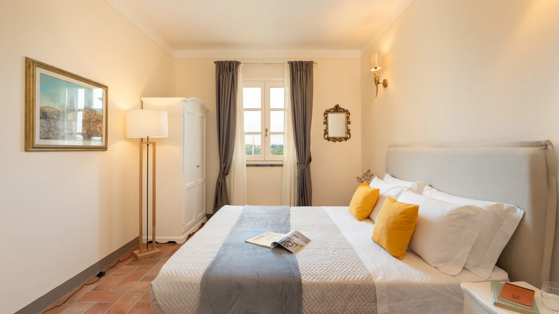 Un dormitorio con una cama, una ventana y una lámpara de pie.