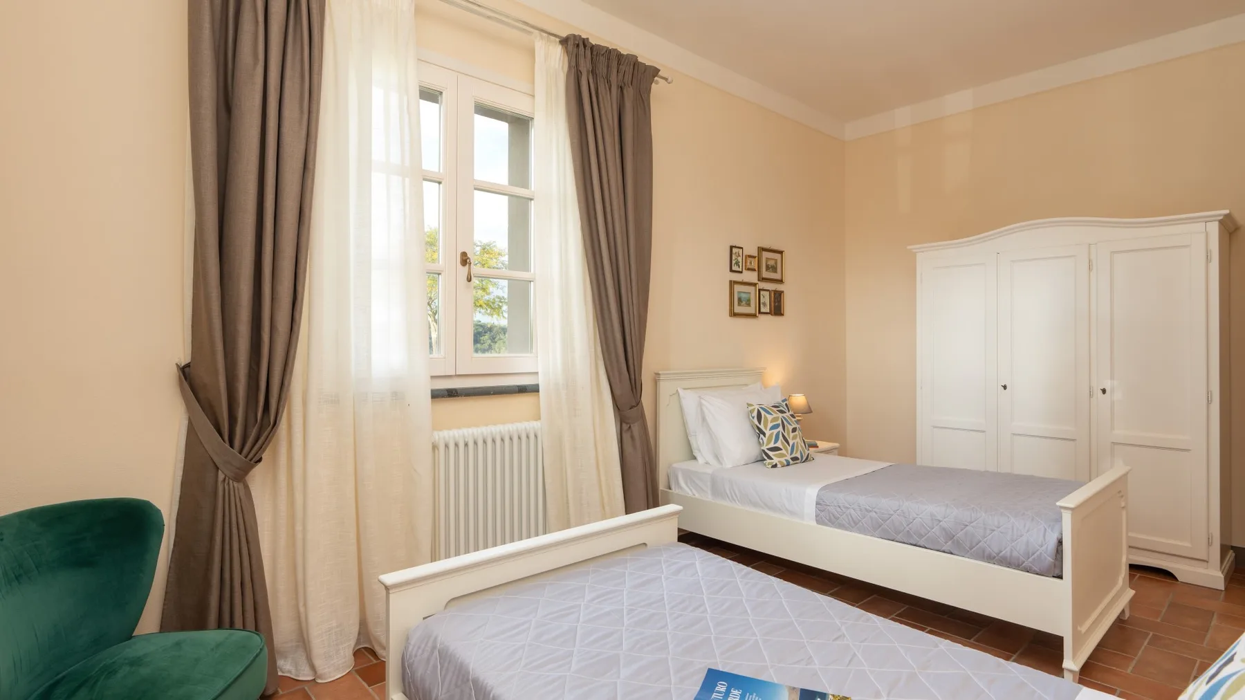Un dormitorio con dos camas, una ventana y un armario blanco.