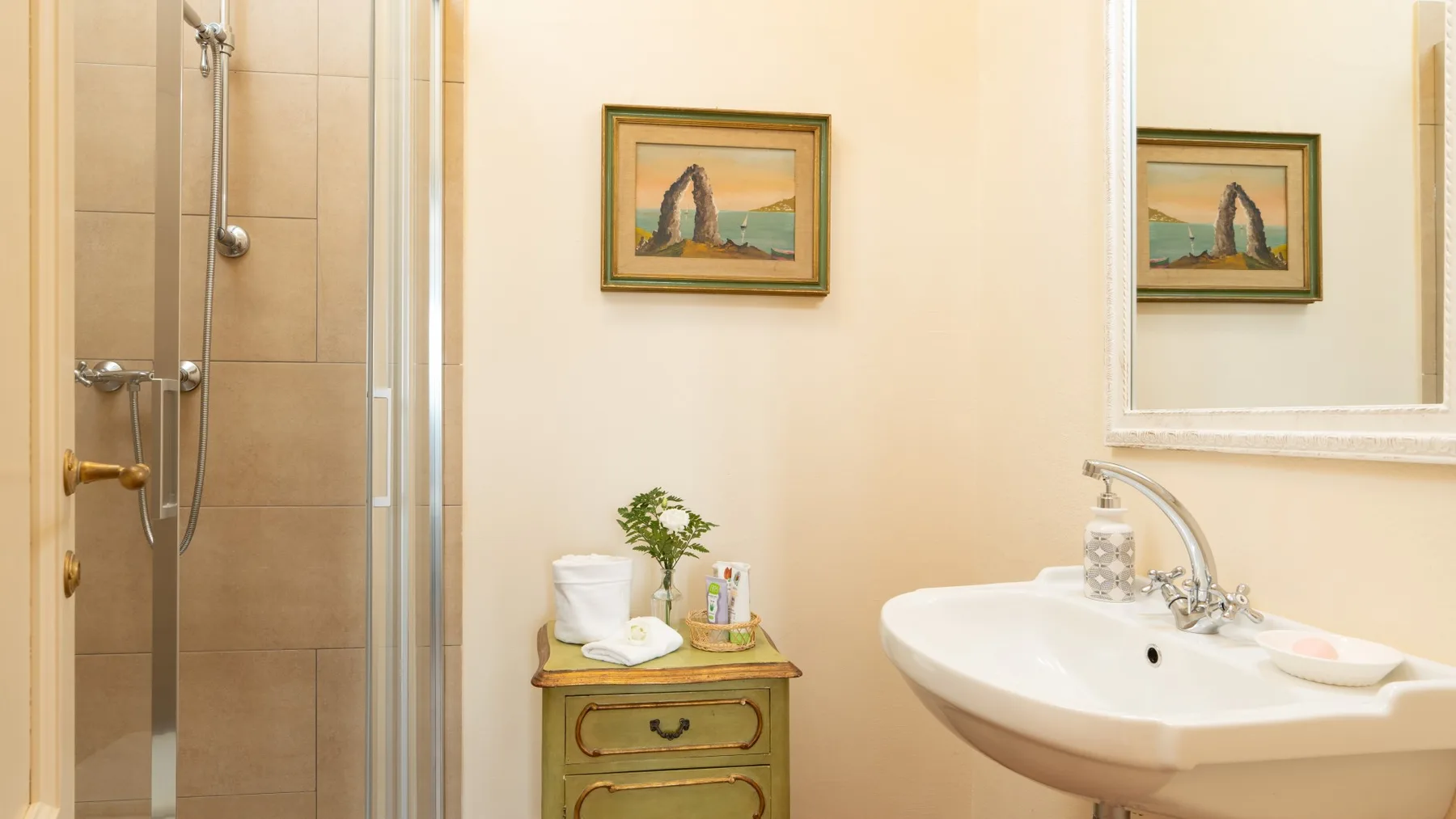 Un baño con lavabo, ducha y un pequeño armario.