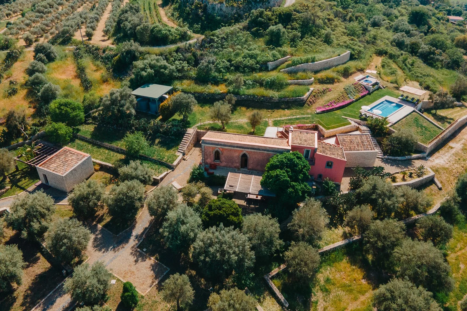 Vista aérea de una propiedad rural con jardines y una piscina.