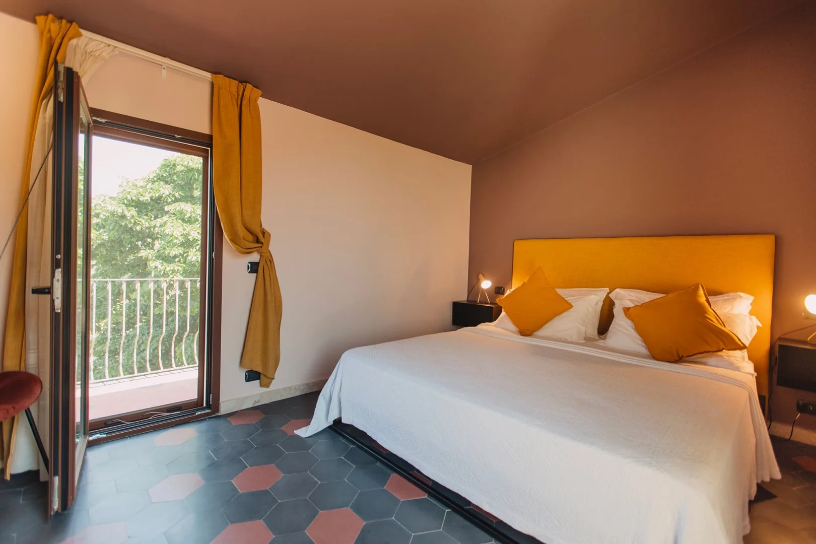 Un dormitorio con una cama junto a una puerta de vidrio que da a un balcón.