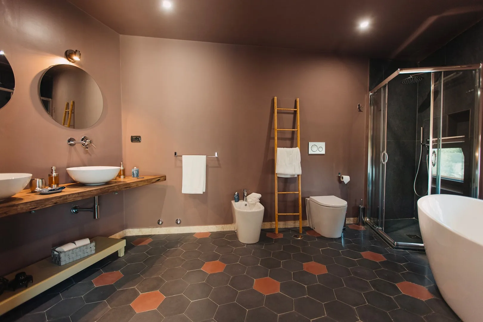 Un baño con un mueble de lavabo largo, una ducha y una bañera exenta.