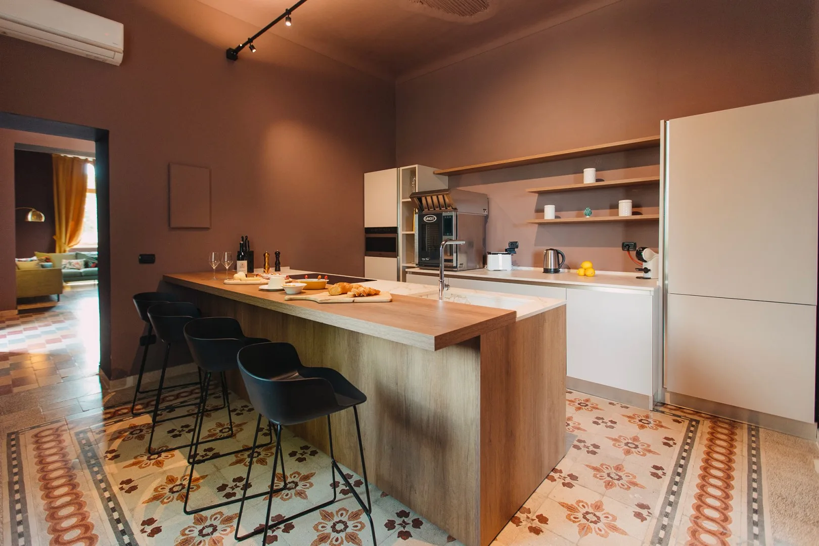 Una cocina con una isla larga y asientos de barra.