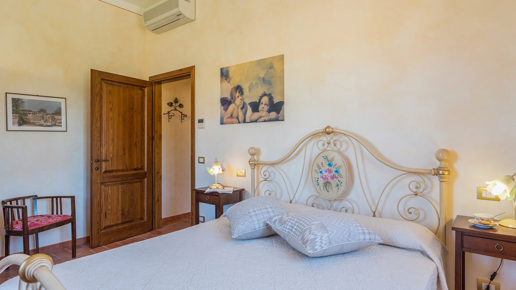 A bedroom with a large bed and a decorative headboard.