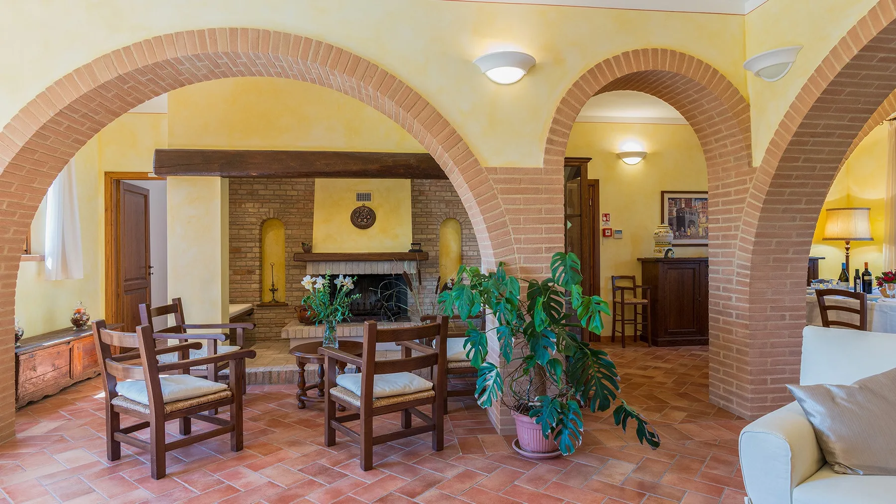 A living room with brick arches, seating, and a fireplace.