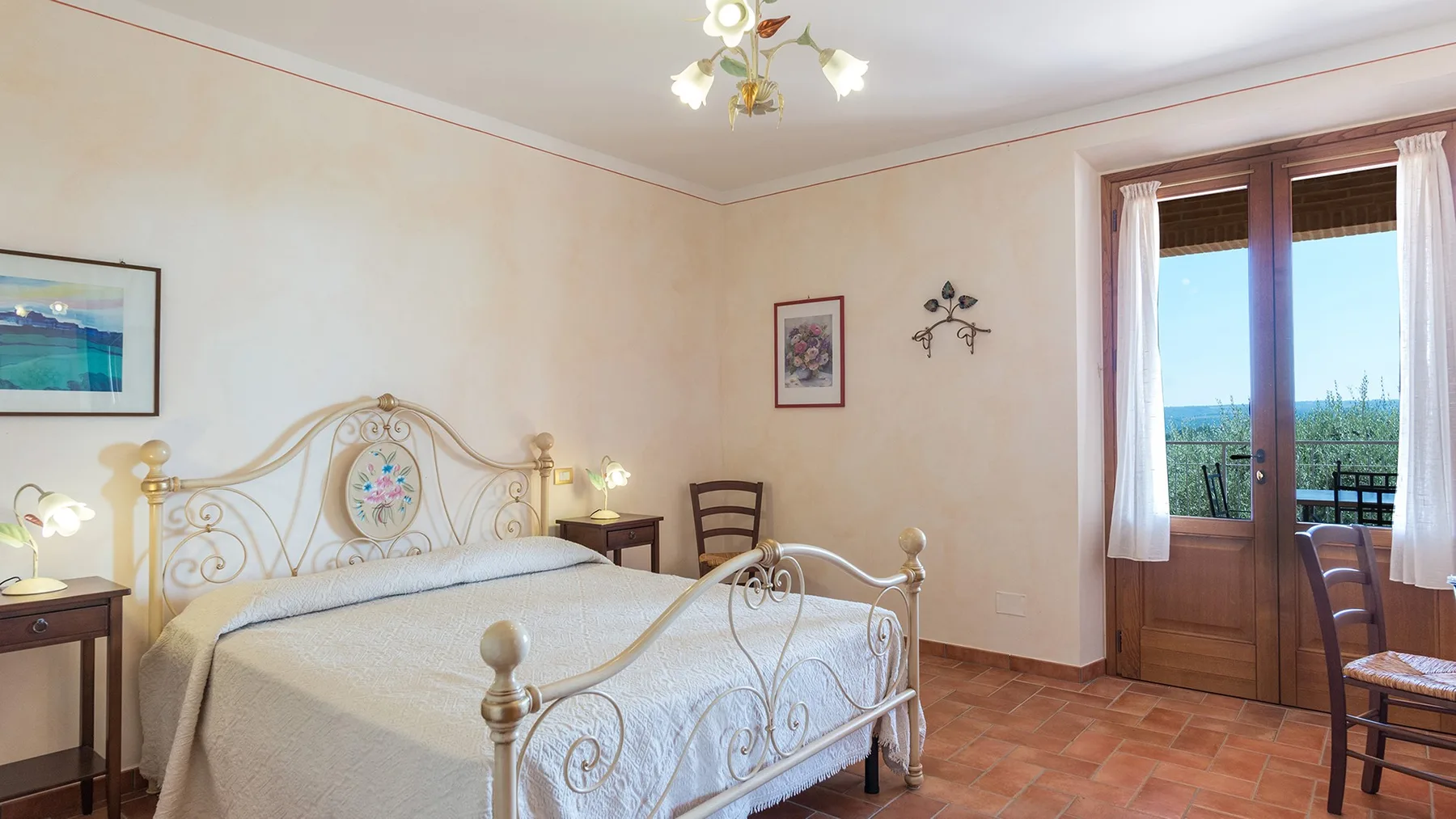 A bedroom with a metal bed and glass doors opening onto a balcony.