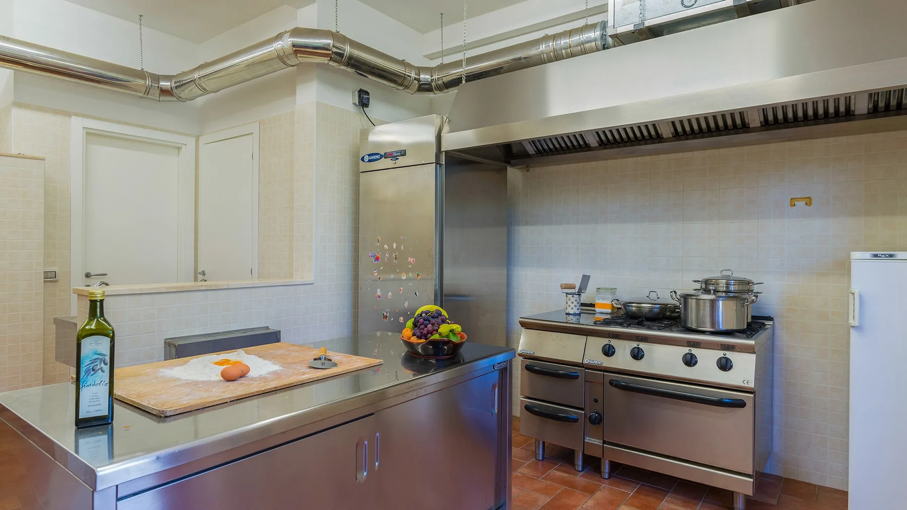 A commercial kitchen with stainless steel cooking equipment and a food preparation counter.
