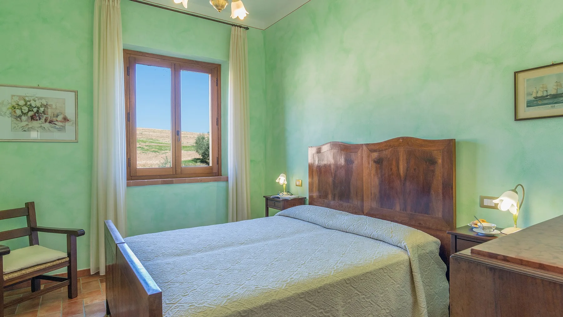 A bedroom with a double bed, a wooden headboard, and a window.
