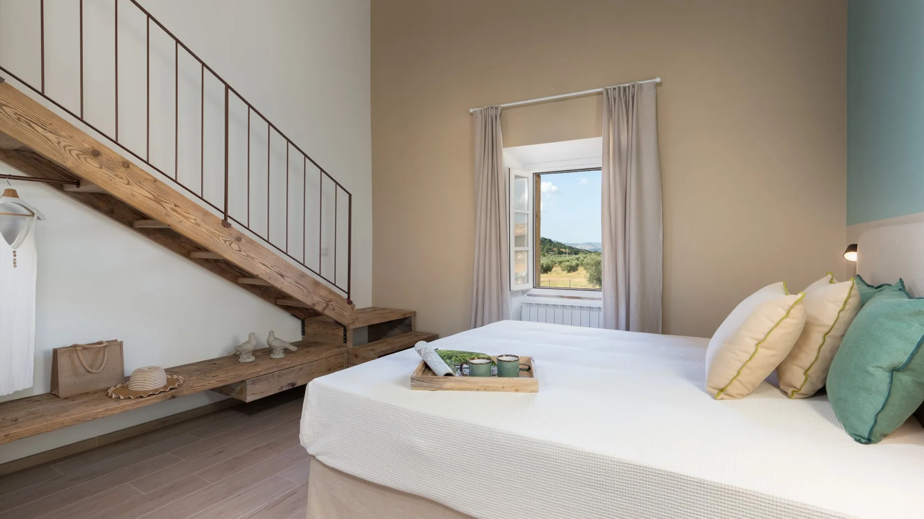 Un dormitorio con una cama grande y una ventana bajo una escalera.