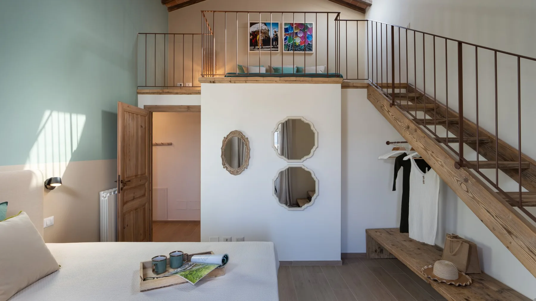 Un dormitorio con una cama junto a una escalera y un pequeño rellano.