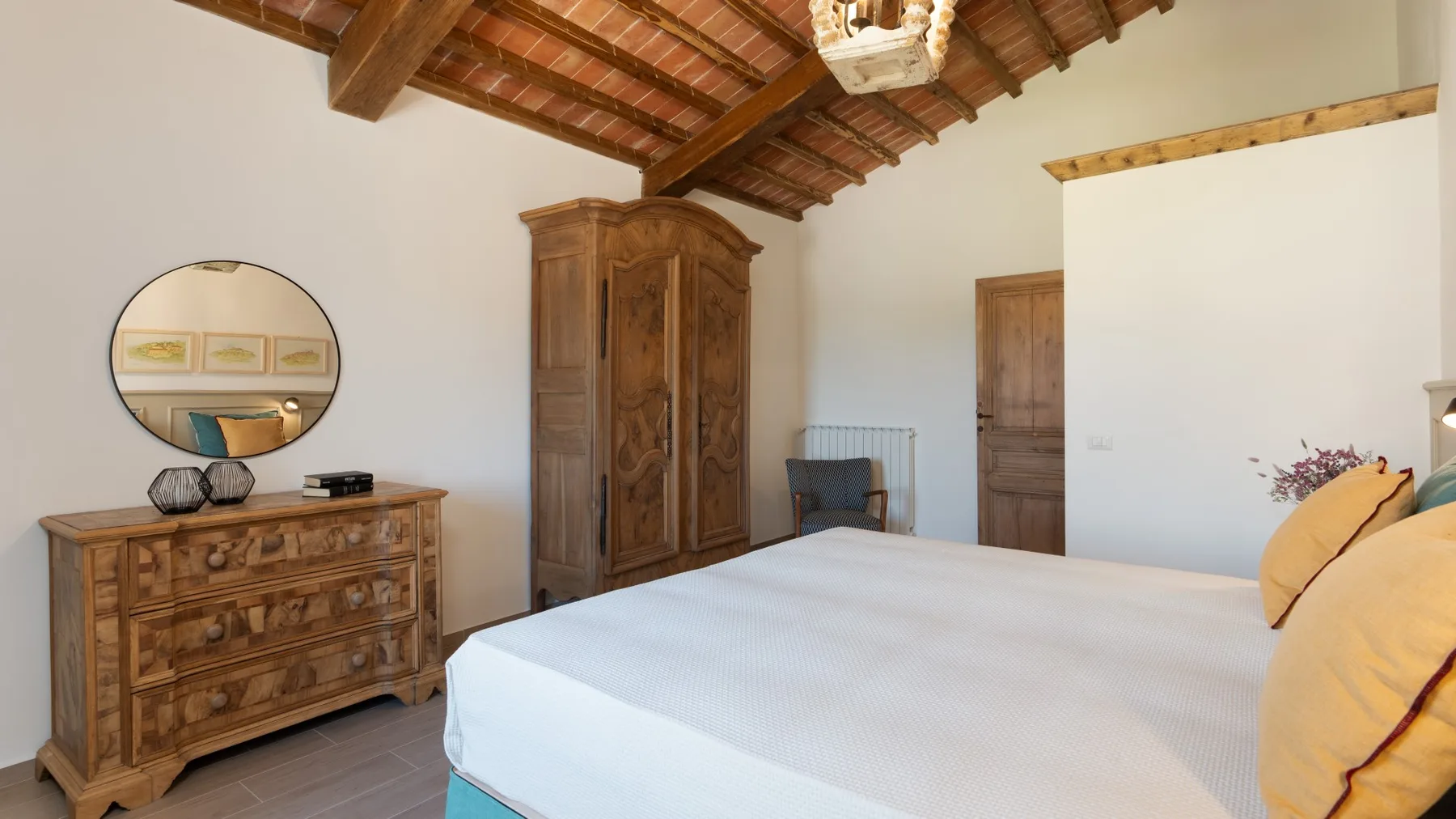 Un dormitorio con una cama grande, un armario de madera y una cómoda.