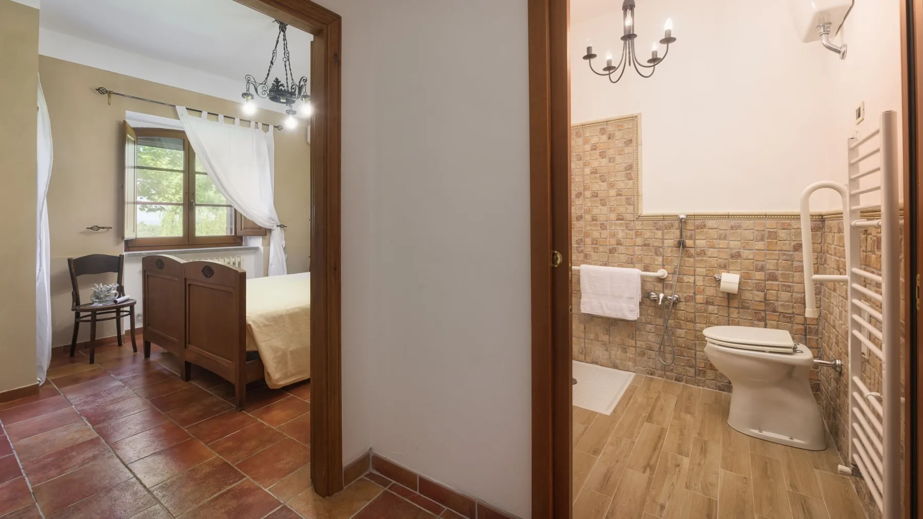A través de una puerta abierta se ve un dormitorio con cama de madera, silla y ventana.