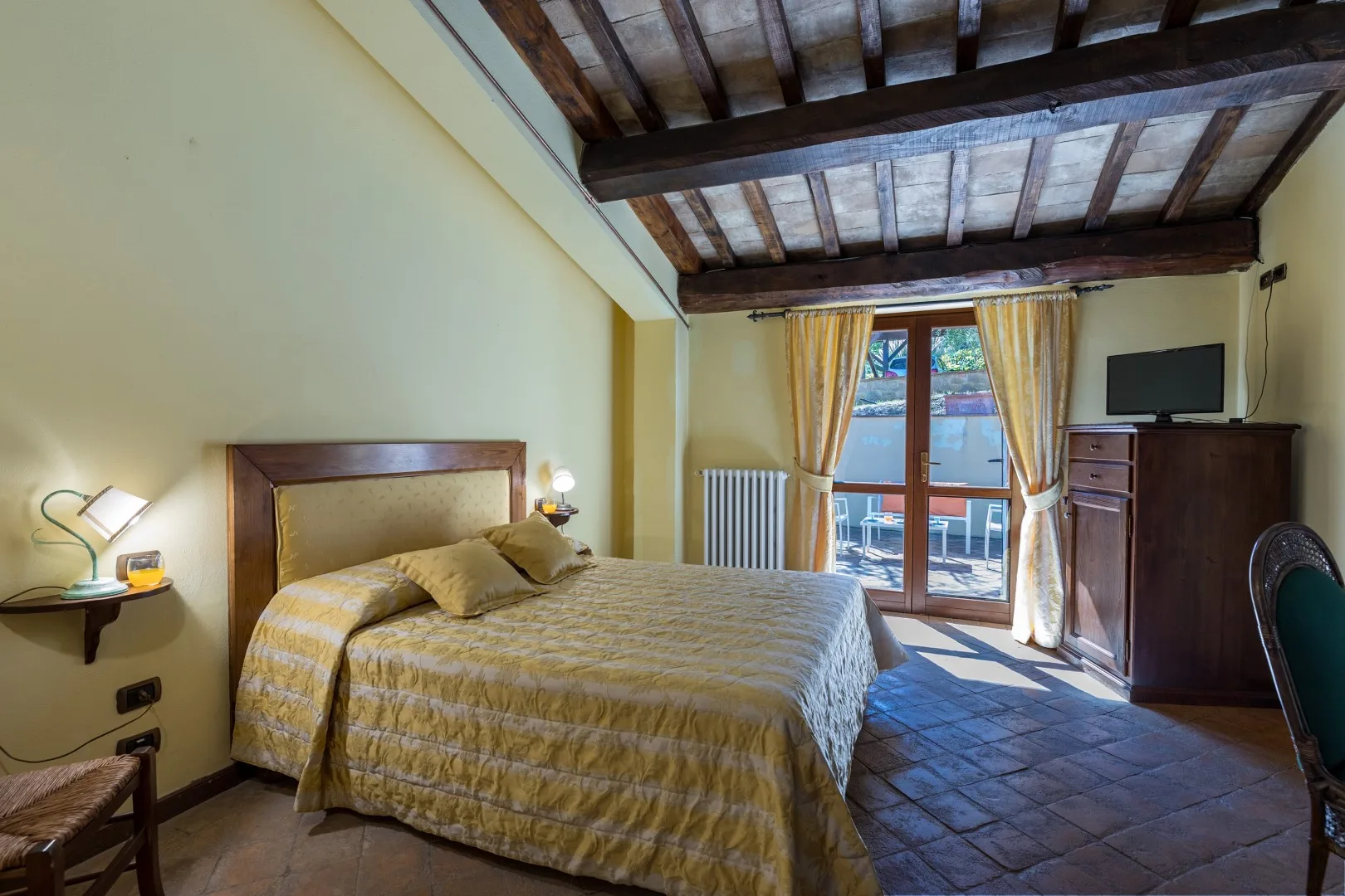 Un dormitorio con una cama doble y puertas de vidrio que dan a un balcón.