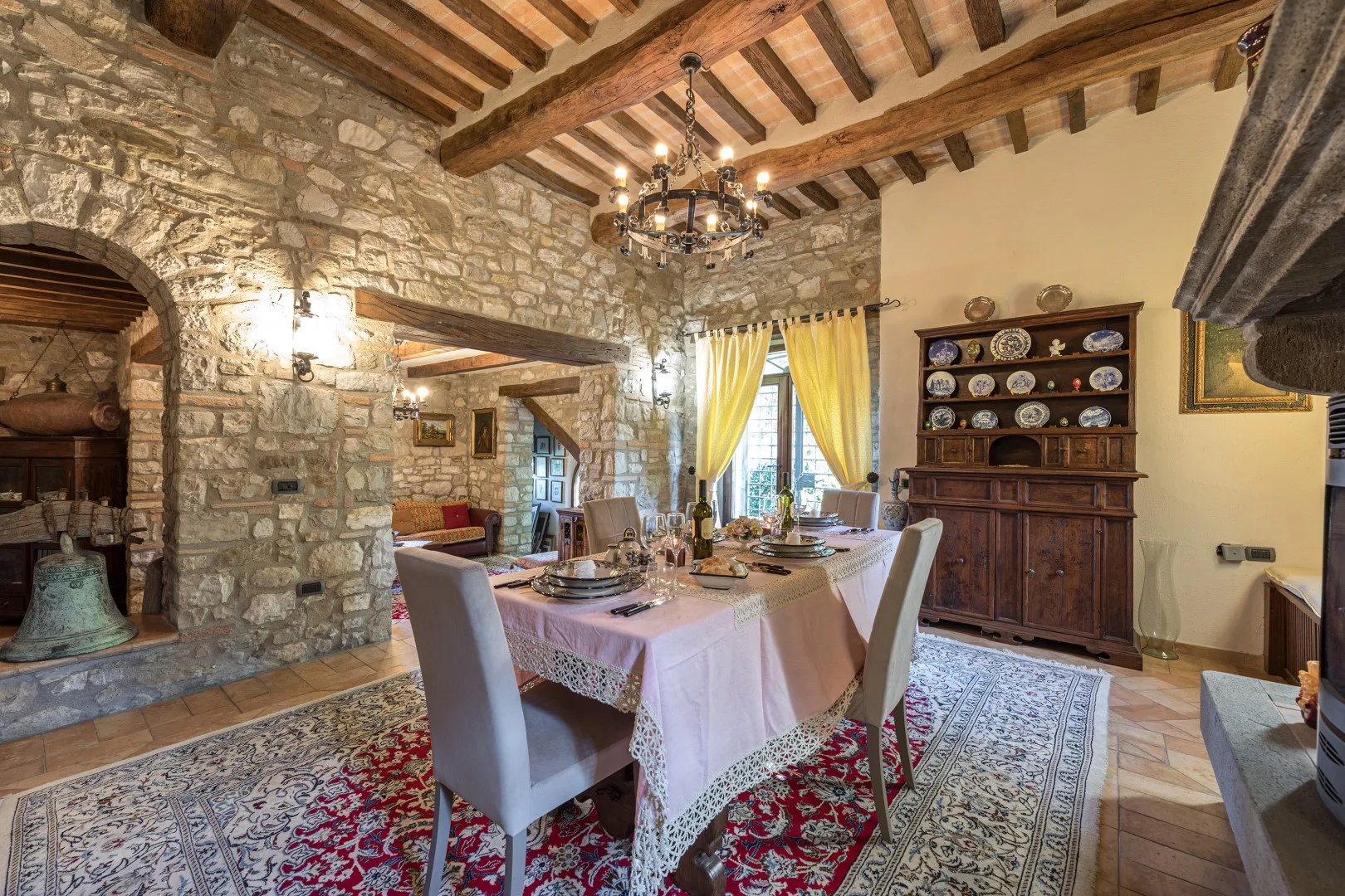 Comedor con una mesa preparada bajo vigas de madera expuestas.