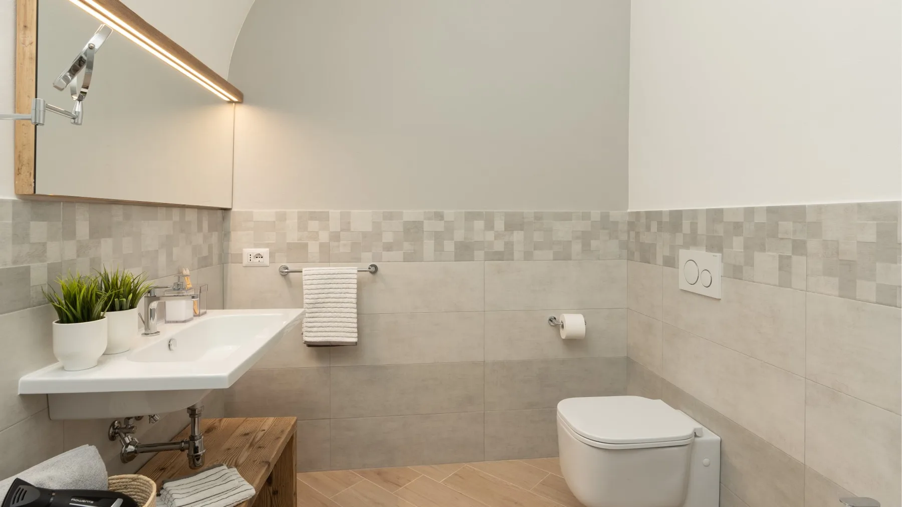 A bathroom with a sink, mirror, and toilet.