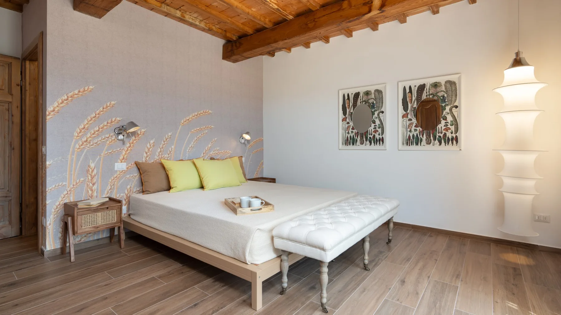 A bedroom with a bed, bedside table, and exposed wooden ceiling beams.
