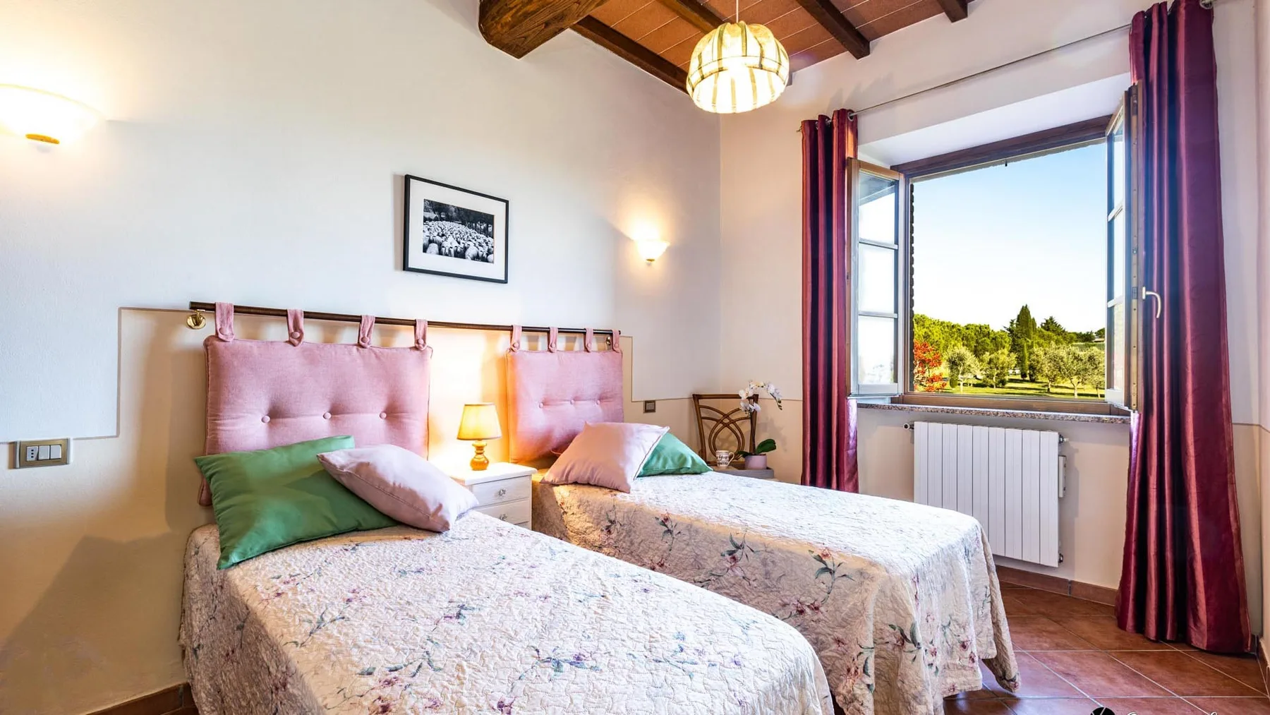 Un dormitorio con dos camas y una ventana grande abierta.