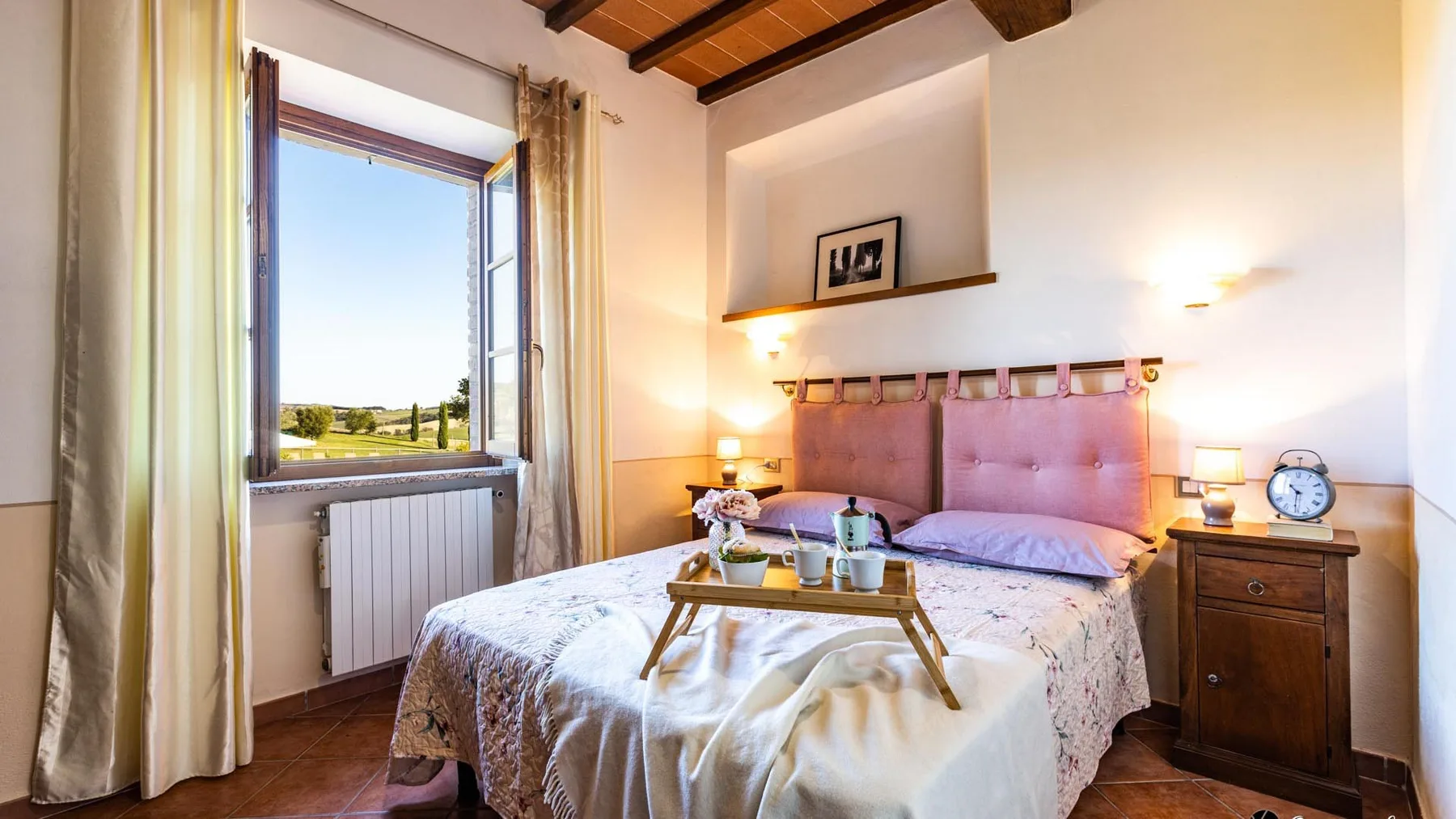Un dormitorio con una cama doble, mesitas de noche y una ventana grande.