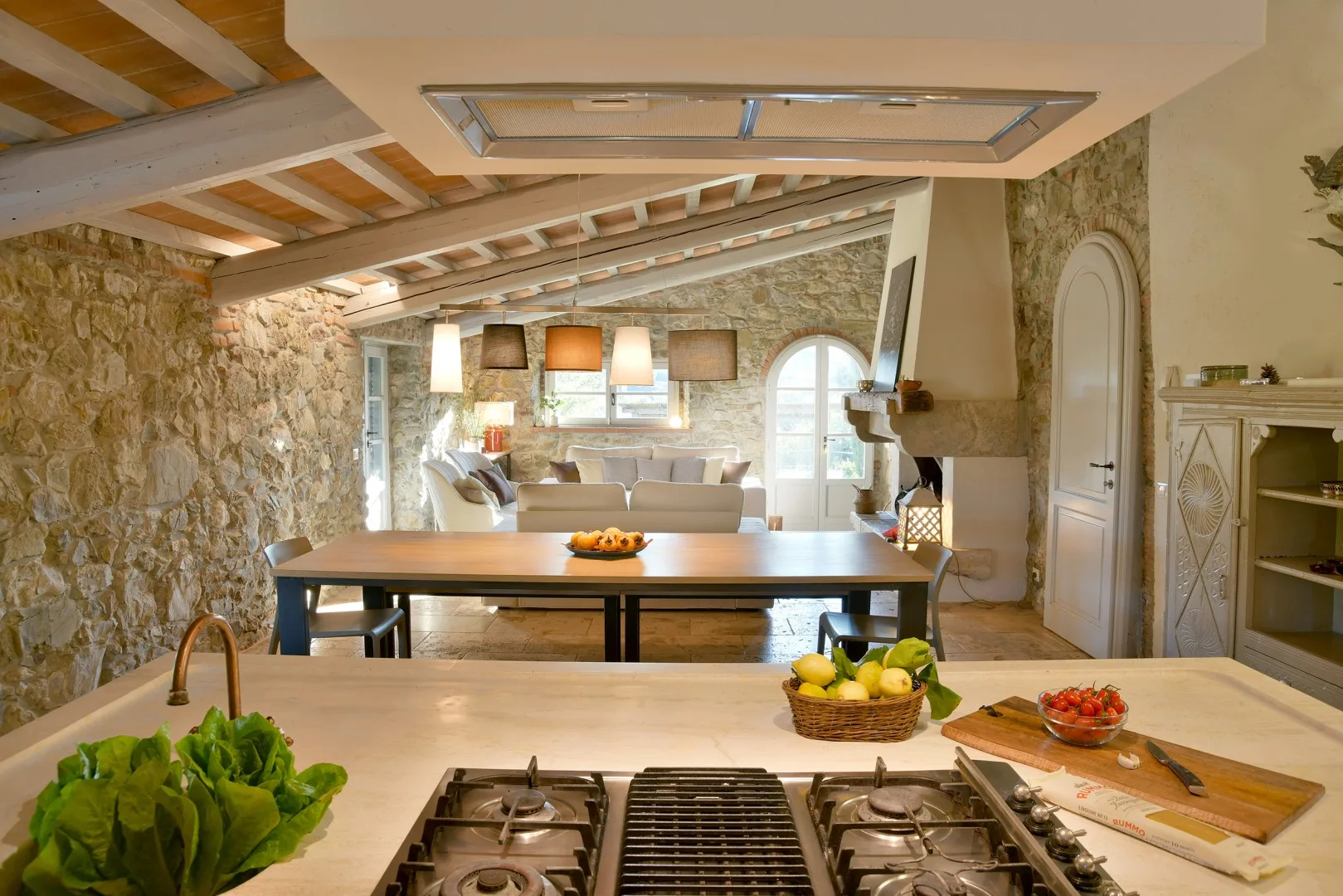 Una cocina rústica con una isla central y una mesa de comedor al fondo.